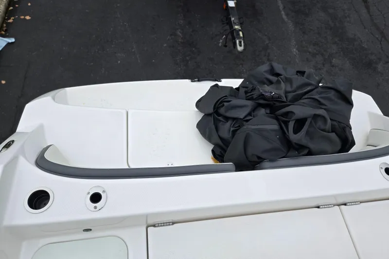 Slide: The Image of 2022 Yamaha Boats 210 FSH Sport deck with black cover, trailer visible. - 30