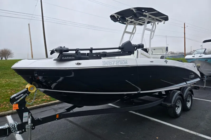 Slide: The Image of 2022 Yamaha Boats 210 FSH Sport on trailer, featuring Garmin equipment, parked outdoors. - 6