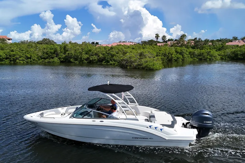 The Image of 2020 Chaparral 23 SSi boat cruising on a scenic river with lush greenery. - 0