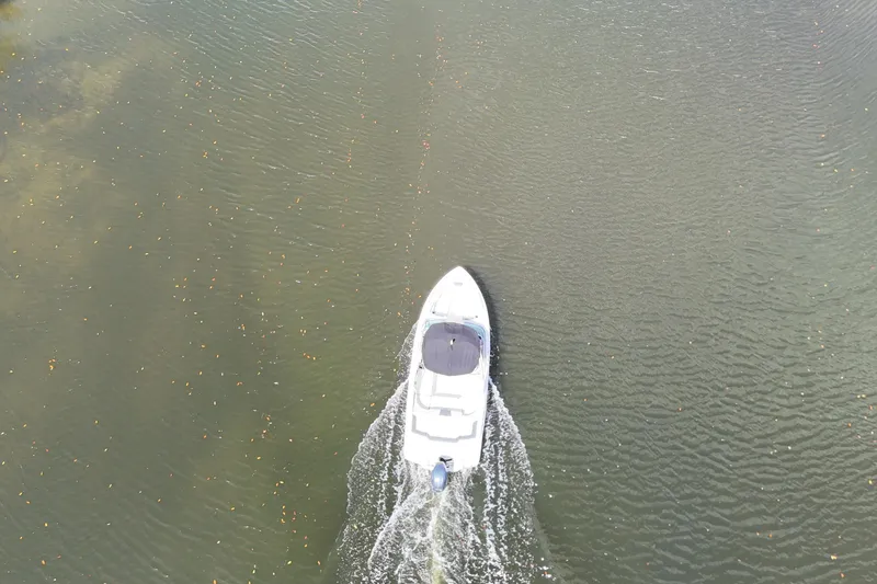 Slide: The Image of Aerial view of 2020 Chaparral 23 SSi boat cruising on calm water. - 10