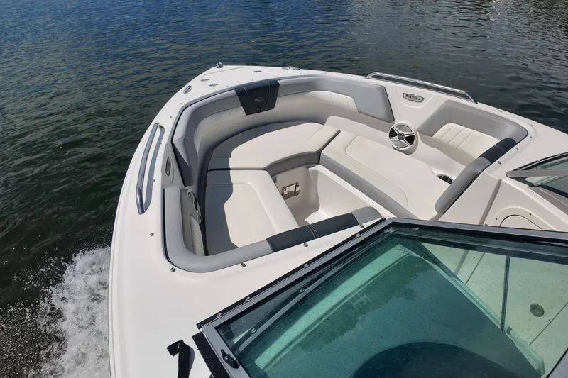 Slide: The Image of 2020 Chaparral 23 SSi boat interior with cushioned seating on calm water. - 13