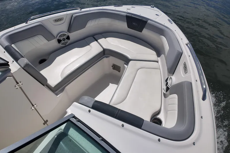 Slide: The Image of 2020 Chaparral 23 SSi boat interior with cushioned seating and speakers on a calm water backdrop. - 14