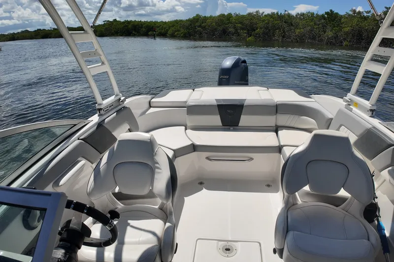 Slide: The Image of 2020 Chaparral 23 SSi boat interior with seating, on a calm lake. - 15