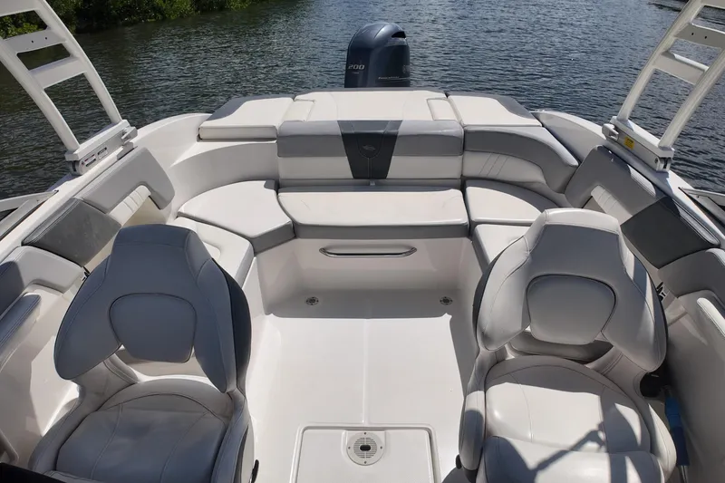 Slide: The Image of 2020 Chaparral 23 SSi boat interior with white seating on calm water. - 16