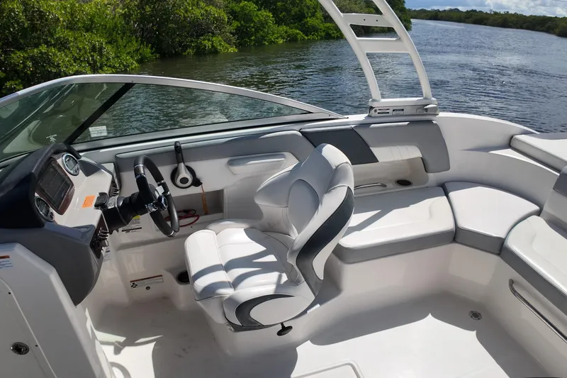 Slide: The Image of 2020 Chaparral 23 SSi boat interior with steering wheel and seating, near water. - 17
