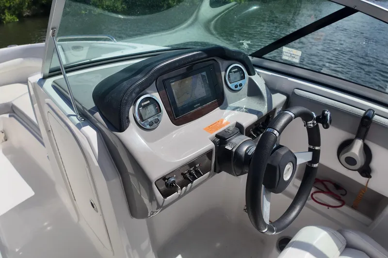 Slide: The Image of 2020 Chaparral 23 SSi boat dashboard with steering wheel and navigation controls. - 19