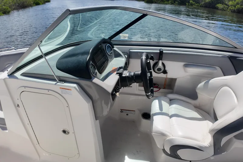 Slide: The Image of 2020 Chaparral 23 SSi boat interior with steering wheel and white seating. - 22