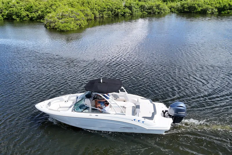 Slide: The Image of 2020 Chaparral 23 SSi boat cruising on a calm river with lush greenery. - 7