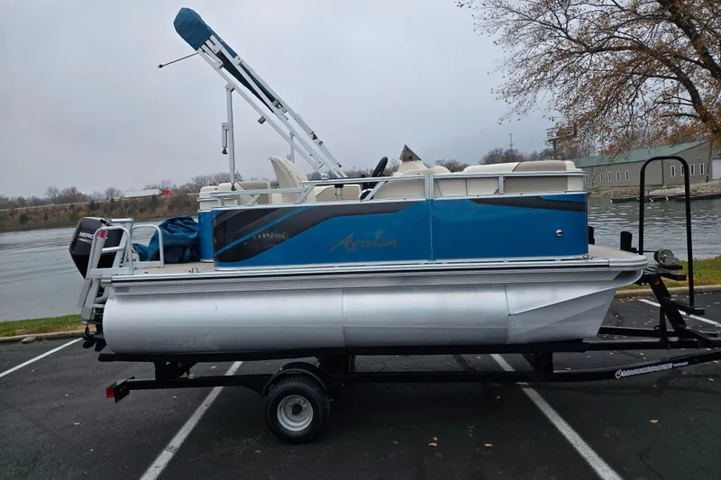 Slide: The Image of 2023 Avalon Venture CR 1575 pontoon boat on trailer by a riverbank. - 10