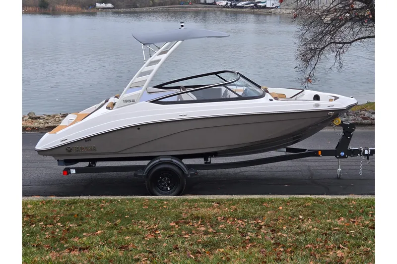 The Image of 2023 Yamaha Boats 195S on trailer by a lakeside, showcasing sleek design. - 0
