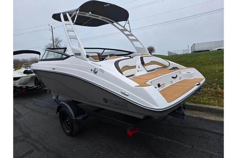 Slide: The Image of 2023 Yamaha Boats 195S, sleek design, white hull, on trailer, outdoor display. - 3