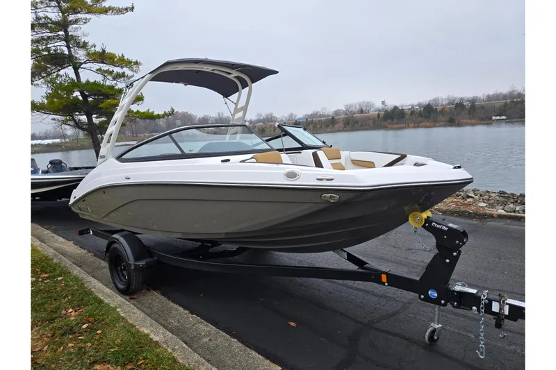 Slide: The Image of 2023 Yamaha Boats 195S on trailer by a lakeside, showcasing sleek design and modern features. - 8