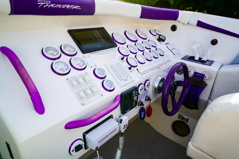 Slide: The Image of Interior of a 2000 Active Thunder 32 boat with white seating and purple carpet. - 12