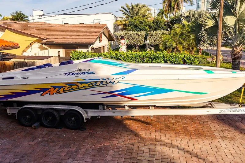 Slide: The Image of Overhead view of a 2000 Active Thunder 32 boat with vibrant graphics and purple cover. - 2