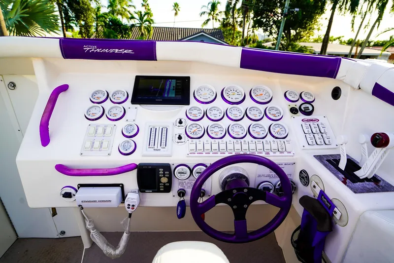 Slide: The Image of Interior of a 2000 Active Thunder 32 boat with purple and white seating and control panel. - 9