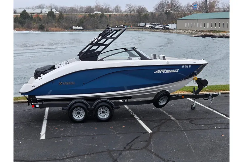 The Image of 2025 Yamaha Boats AR220 on trailer by waterfront, showcasing sleek design and modern features. - 0