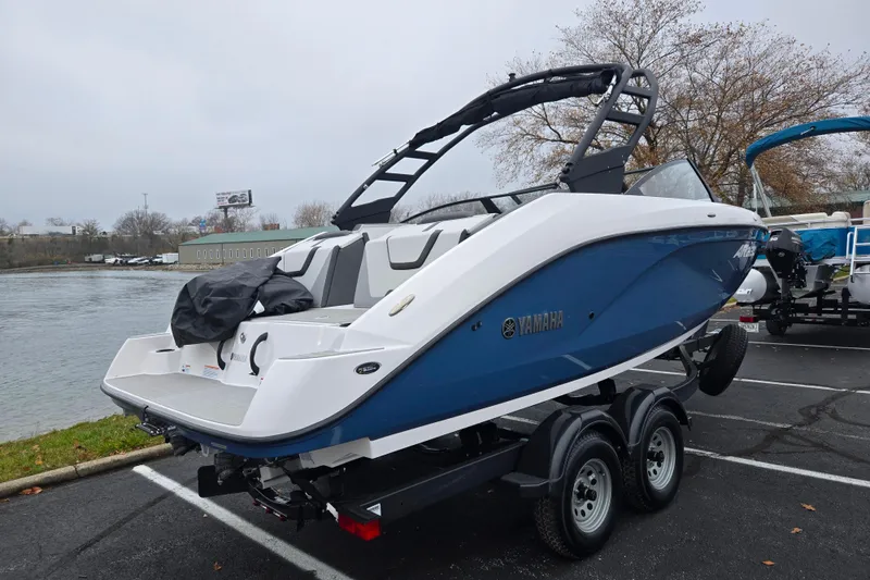 Slide: The Image of 2025 Yamaha Boats AR220 on trailer by waterfront, showcasing sleek design and modern features. - 1