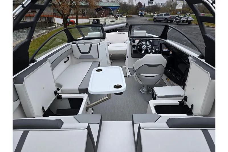 Slide: The Image of 2025 Yamaha Boats AR220 interior with seating, steering wheel, and table in a sleek design. - 10