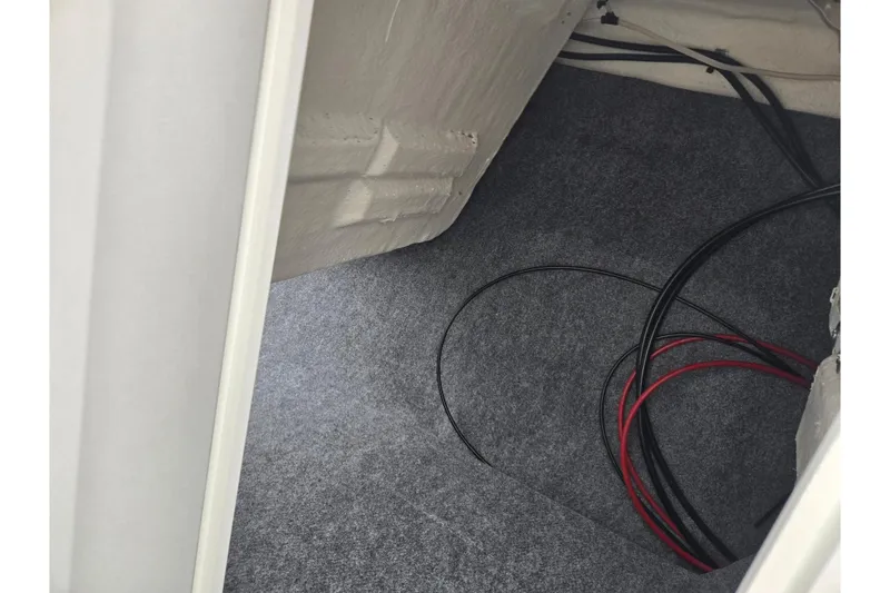 Slide: The Image of Interior view of 2025 Yamaha AR220 boat showing wiring and carpeted flooring. - 17