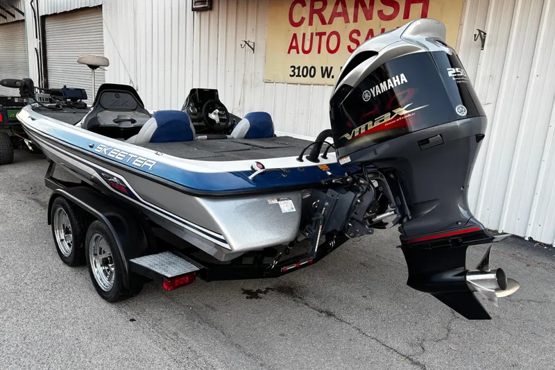 Slide: The Image of 2014 Skeeter ZX20 boat interior with steering wheel and seating, parked outdoors. - 29