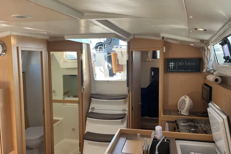 Slide: The Image of Interior of 2020 Beneteau Oceanis 38.1 sailboat with modern kitchen and bathroom amenities. - 13
