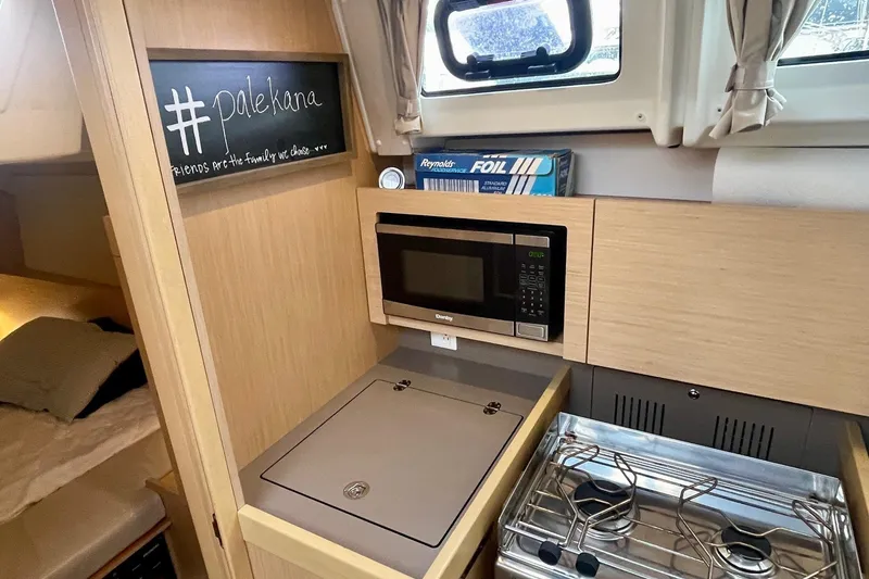 Slide: The Image of Beneteau Oceanis 38.1 yacht kitchen with microwave, stove, and window, 2020 model. - 18