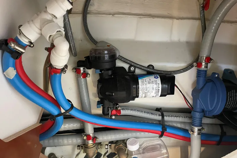 Slide: The Image of Plumbing system inside 2020 Beneteau Oceanis 38.1 yacht, featuring pipes and pump components. - 23