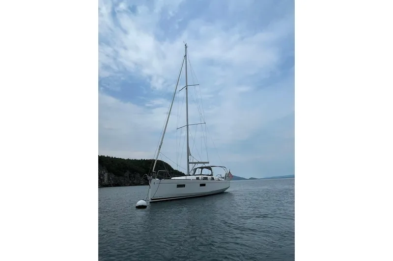 Slide: The Image of 2020 Beneteau Oceanis 38.1 sailboat anchored on calm water under a cloudy sky. - 34