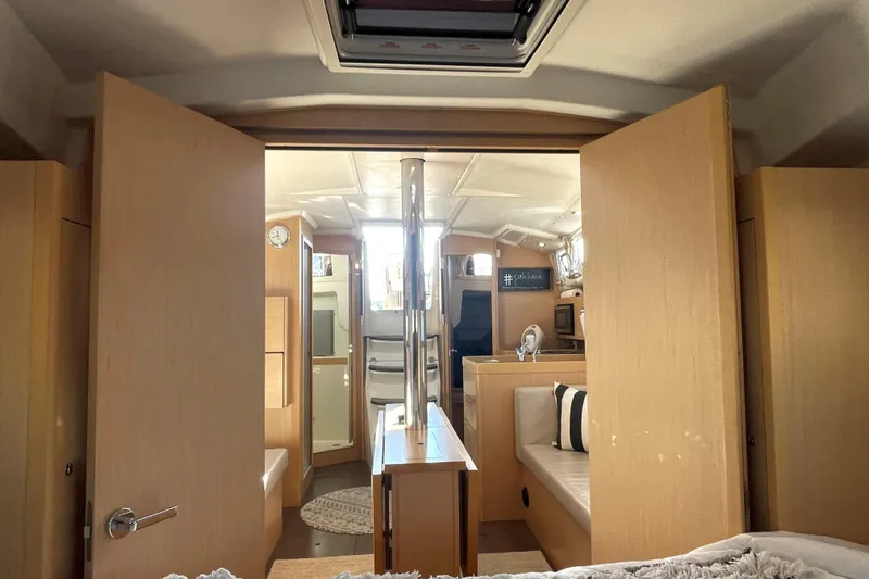 Slide: The Image of Interior of 2020 Beneteau Oceanis 38.1 yacht, featuring modern wood finish and cozy seating. - 6