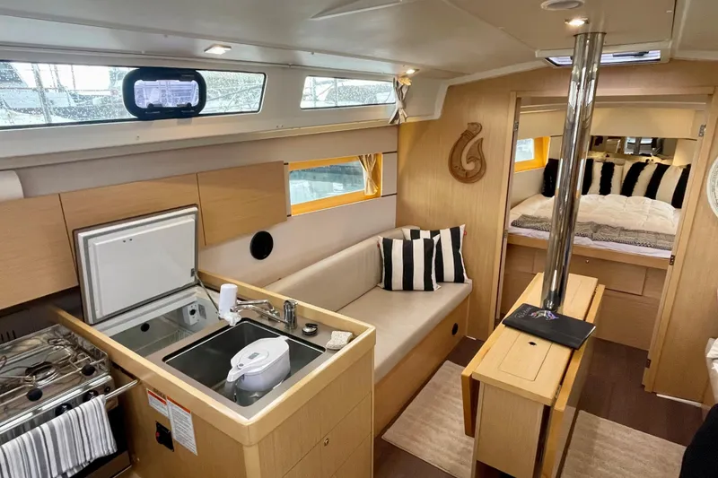 Slide: The Image of Interior of 2020 Beneteau Oceanis 38.1 yacht, featuring modern kitchen and cozy seating area. - 9