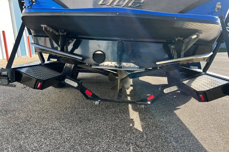 Slide: The Image of 2017 Tigé R21 boat rear view with trailer, propeller, and blue hull. - 15