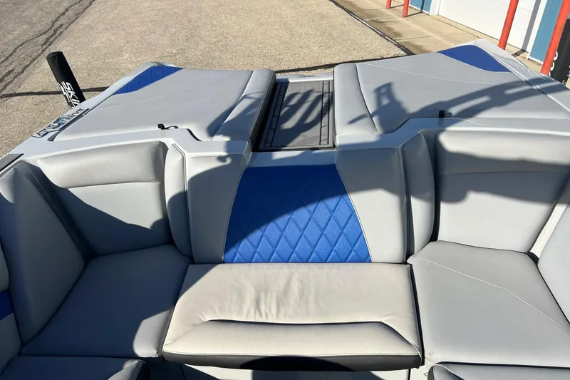 Slide: The Image of 2017 Tigé R21 boat interior with gray and blue seating, outdoor setting. - 28
