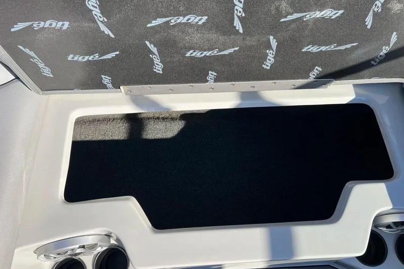 Slide: The Image of 2017 Tigé R21 boat storage compartment with cup holders and branded interior. - 33