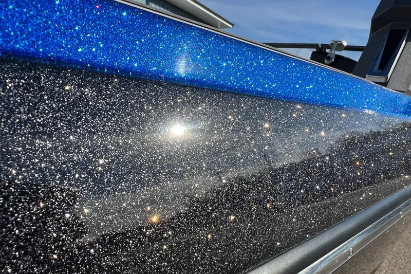 Slide: The Image of 2017 Tigé R21 boat with sparkling blue and black glitter finish under sunlight. - 44