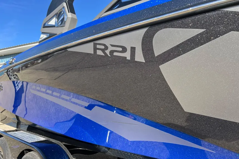 Slide: The Image of 2017 Tigé R21 boat with sleek blue and gray design, close-up view. - 8