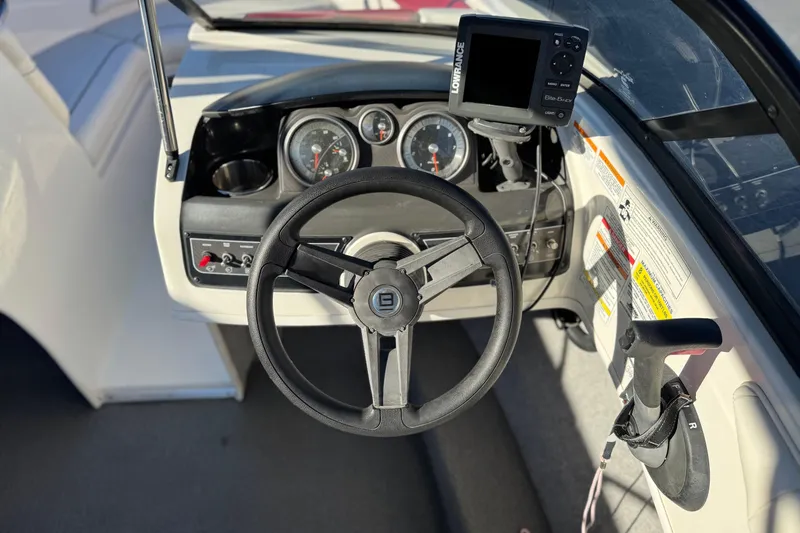 Slide: The Image of 2016 Bayliner 180 Bowrider dashboard with steering wheel and navigation system. - 18