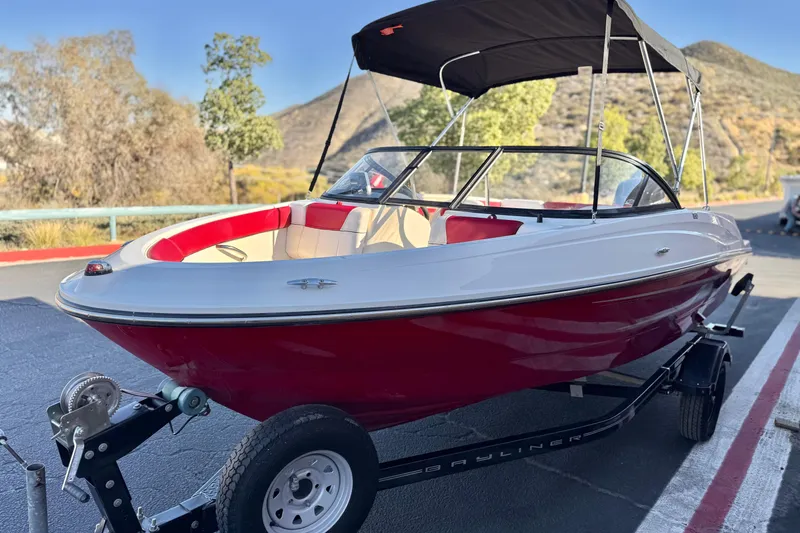 Slide: The Image of 2016 Bayliner 180 Bowrider boat with red and white design on a trailer. - 3