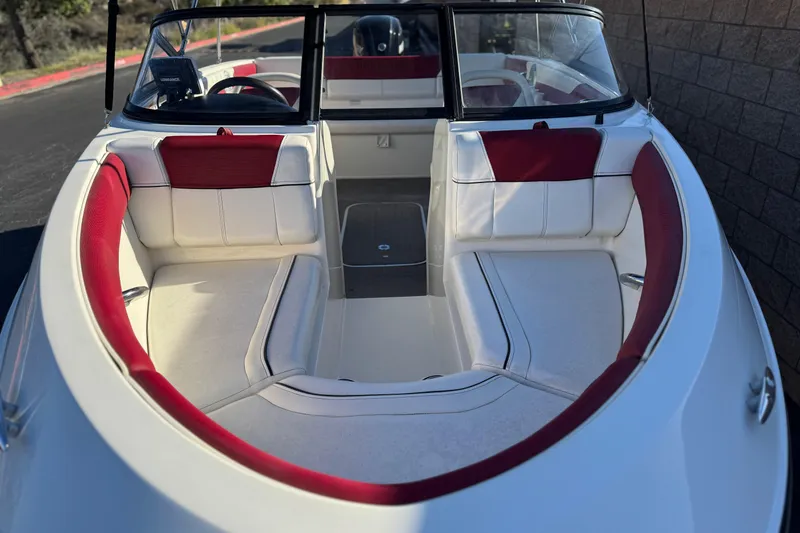 Slide: The Image of 2016 Bayliner 180 Bowrider boat interior with red and white seating. - 8
