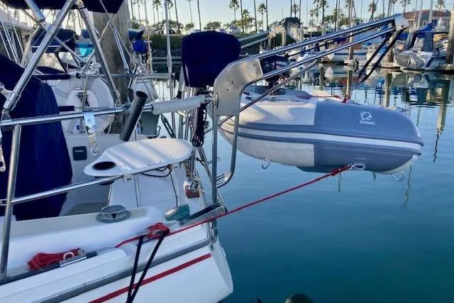 Slide: The Image of 1985 Catalina 36 sailboat with dinghy at marina, calm water, and clear sky. - 3