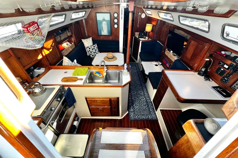 Slide: The Image of Interior of a 1985 Catalina 36 sailboat with cozy wooden furnishings and kitchen area. - 30