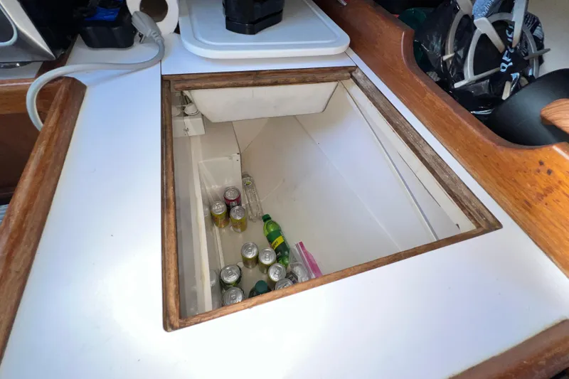 Slide: The Image of Open storage compartment on 1985 Catalina 36 yacht, containing assorted beverage cans. - 32