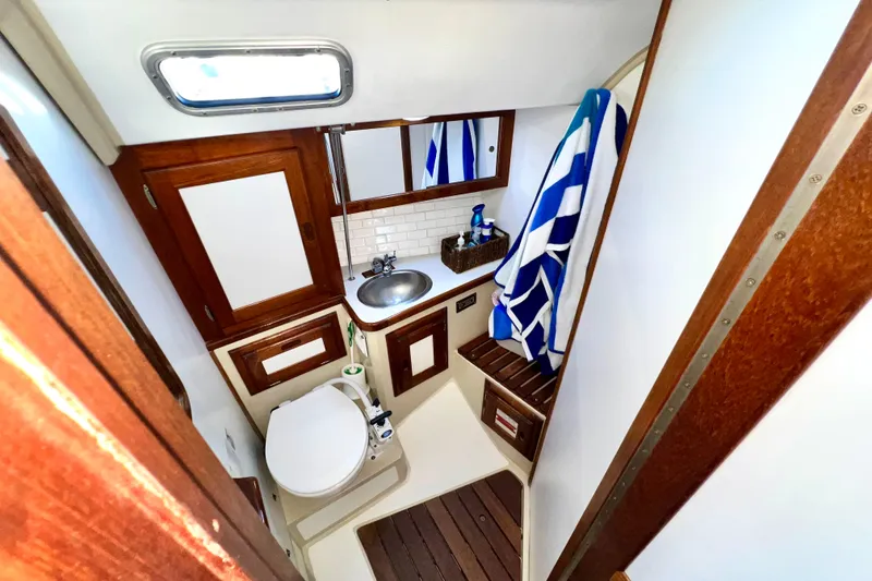 Slide: The Image of 1985 Catalina 36 yacht bathroom with wooden accents, sink, and striped towel. - 45