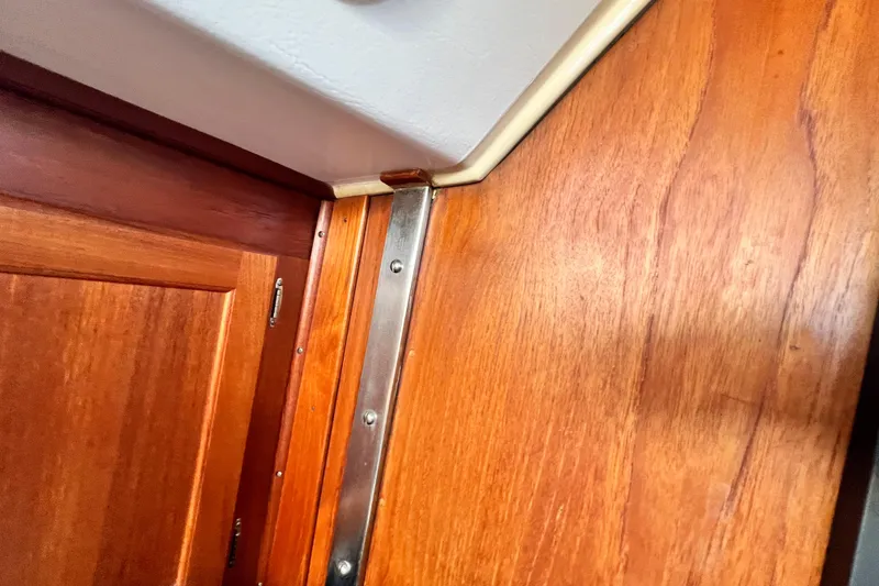 Slide: The Image of Interior woodwork detail of a 1985 Catalina 36 sailboat, featuring polished metal trim. - 50