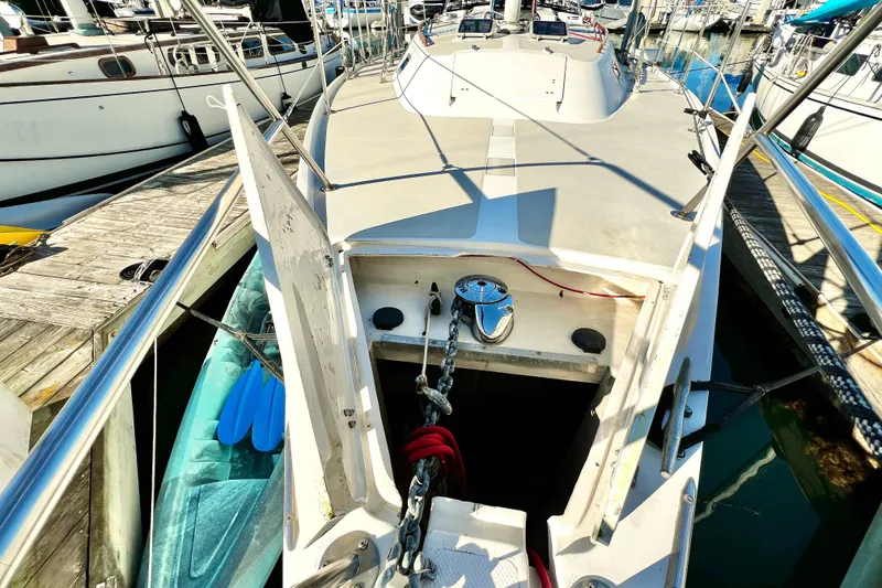 Slide: The Image of 1985 Catalina 36 sailboat at dock, open anchor locker, visible chain and ropes. - 9