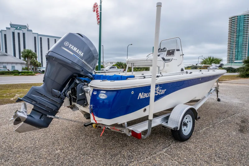 Slide: The Image of 2014 NauticStar 214 XTS boat with Yamaha engine on trailer, urban background. - 2