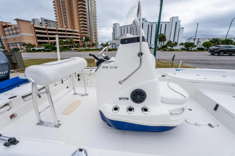 Slide: The Image of 2014 NauticStar 214 XTS boat interior with seating and console, urban backdrop. - 21