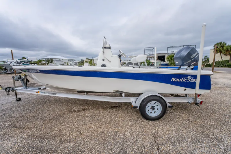 Slide: The Image of 2014 NauticStar 214 XTS boat on trailer, blue and white design, parked outdoors. - 8