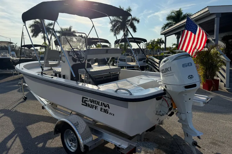 Slide: The Image of 2026 Carolina Skiff E16 JVX CC boat with Suzuki 60 engine, parked outdoors. - 11