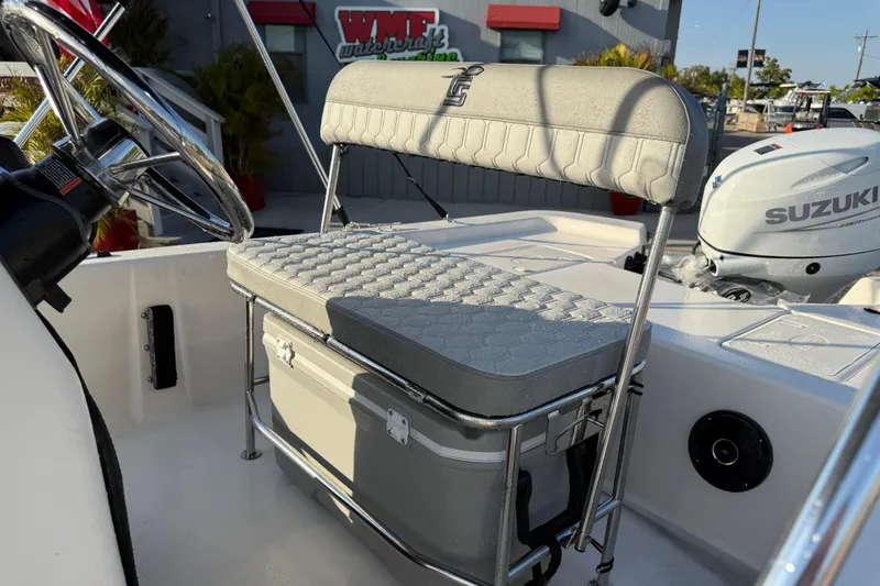 Slide: The Image of 2026 Carolina Skiff E16 JVX CC boat interior with steering wheel and Suzuki engine. - 21