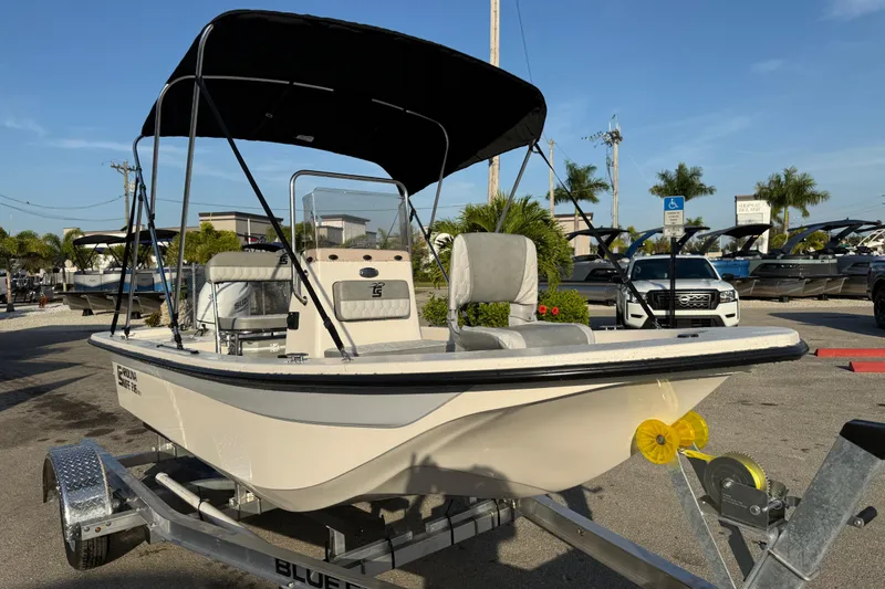 Slide: The Image of 2026 Carolina Skiff E16 JVX CC boat on trailer with canopy in sunny marina. - 5